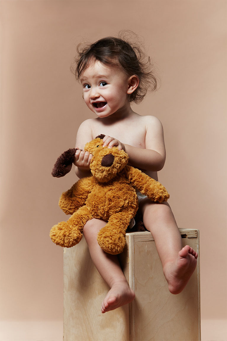 Studio portrait of expressive child and plush animal stuffie